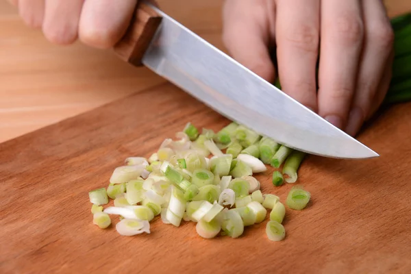 Cebollas verdes picadas sobre tabla de madera de cerca — Foto de Stock