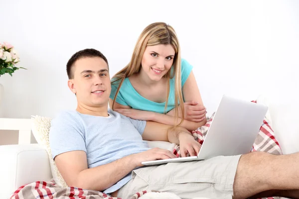 Casal amoroso sentado com laptop no sofá, em casa fundo interior — Fotografia de Stock