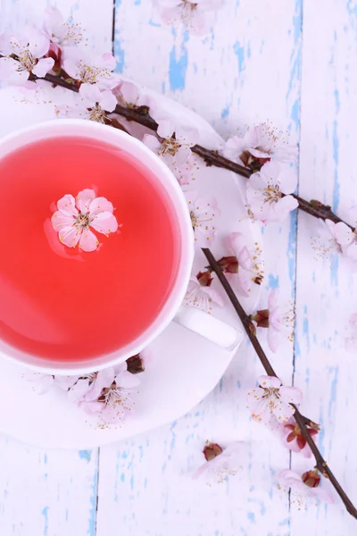 Fragrant tea with flowering branches on wooden table close-up — Stock Photo, Image