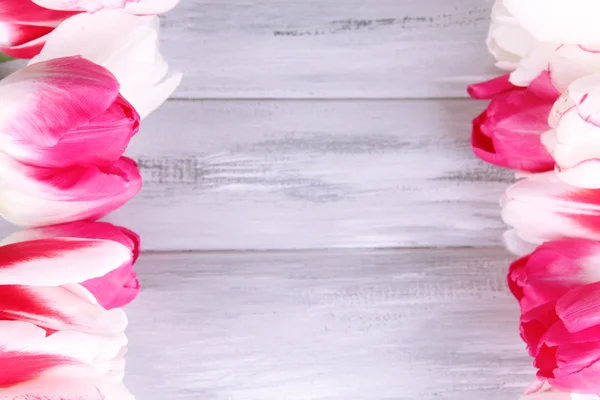 Krásné tulipány na barevné dřevěné pozadí — Stock fotografie