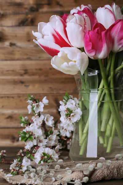 Hermosos tulipanes en jarra de vidrio sobre fondo de madera —  Fotos de Stock