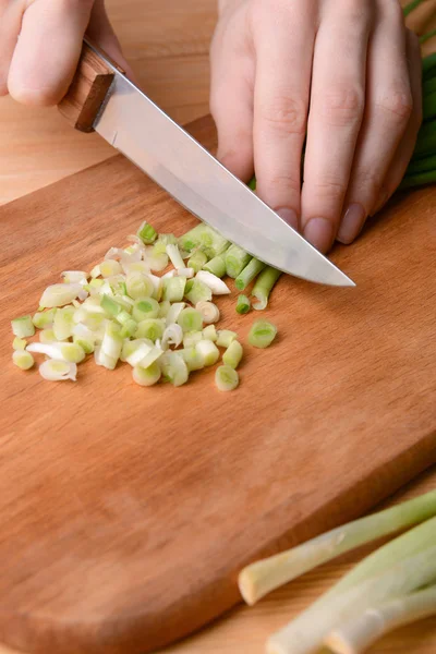 Posiekaną zieloną cebulką na desce z bliska — Zdjęcie stockowe