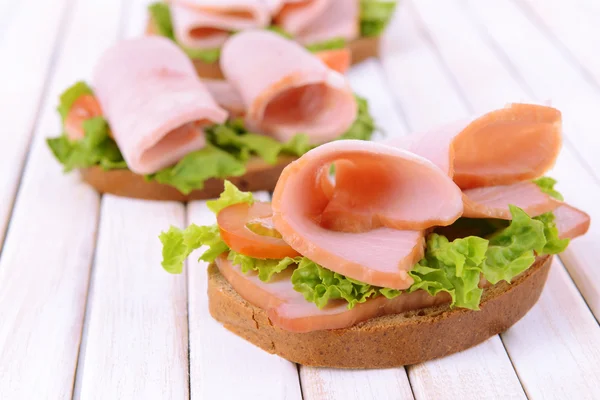 Sanduíches deliciosos com alface e presunto na mesa close-up — Fotografia de Stock