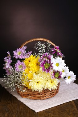 hasır sepet kahverengi zemin üzerine masada güzel kasımpatı çiçekleri