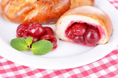 Tablo yakın çekim tabağa kiraz ile taze pişmiş pasties