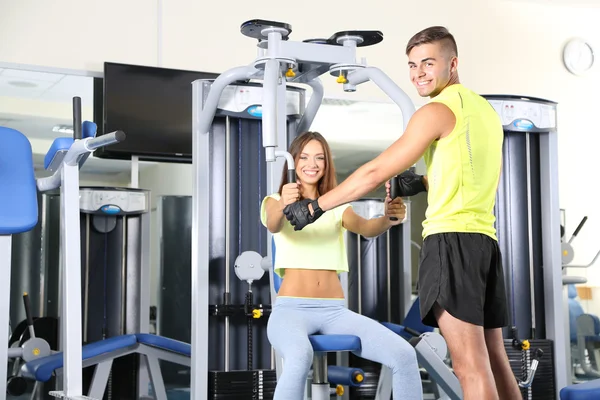 Girl and trainer engaged in simulator in gym — Stock Photo, Image