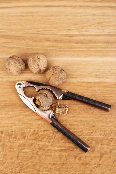 Nutcracker and walnuts  on wooden background — Stock Photo, Image