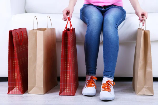 Woman sit on sofa with bags of shopping close-up — Stock Photo, Image