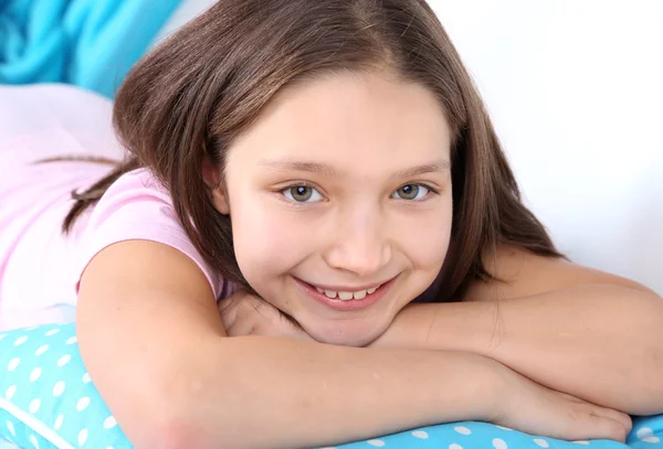 Beautiful little girl sitting on sofa with  book, on home interior background — Stock Photo, Image