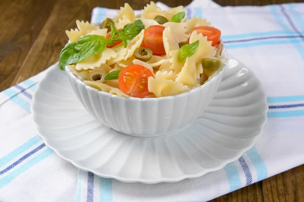 Heerlijke pasta met tomaten op plaat op tabel close-up — Stockfoto