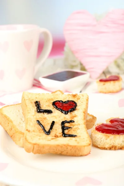 Delicious toast with jam and cup of tea on table close-up — Stock Photo, Image