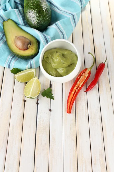 Fresh guacamole in bowl on wooden table — Stock Photo, Image