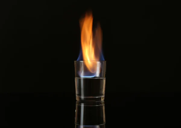 Üveg alkohol fekete háttér előtt égő — Stock Fotó