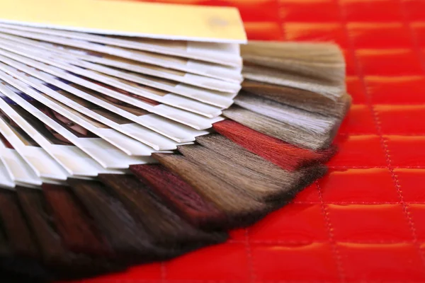 Sammansättningen med hår prover av olika färger, pensel och färg på tabellbakgrund — Stockfoto