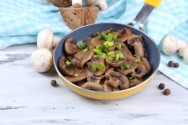 Heerlijke gebakken champignons in pan op tafel close-up — Stockfoto