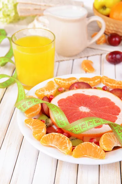 Свежие фрукты на тарелке на столе крупным планом — стоковое фото