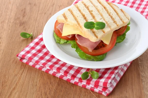 Leckeres Sandwich mit Schinken auf Holztisch — Stockfoto