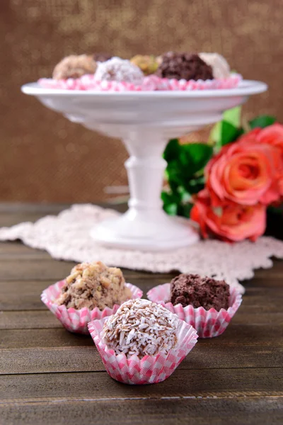 Conjunto de bombones de chocolate sobre mesa sobre fondo marrón — Foto de Stock