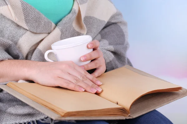 Kadın okuma kitabı ve içecek kahve veya çay, yakın çekim — Stok fotoğraf