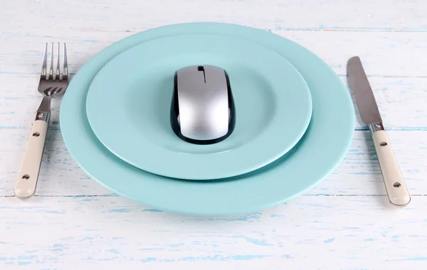 Ratón de ordenador sobre plato con tenedor y cuchillo sobre fondo de madera — Foto de Stock