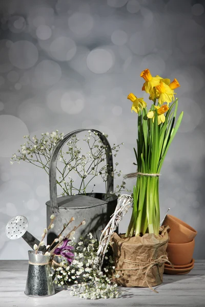 Schöne Frühlingsblumen auf altem Holztisch, auf grauem Hintergrund — Stockfoto