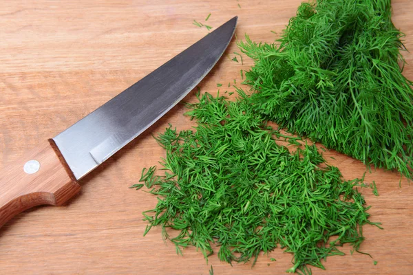 Chopped dill on wooden board close-up — Stock Photo, Image