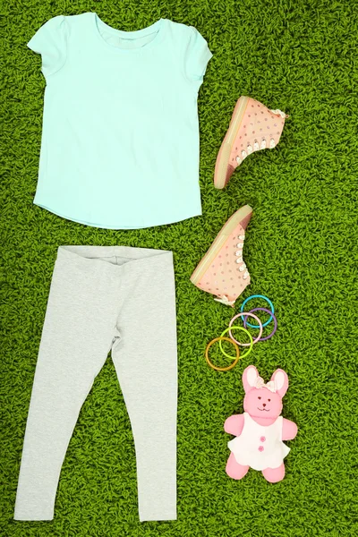 Beautiful clothes for little girl  on green carpet — Stock Photo, Image