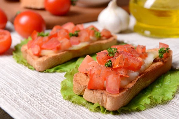 Delicioso bruschetta com tomates na mesa close-up — Fotografia de Stock