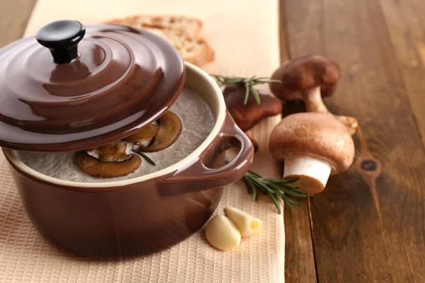 Soupe aux champignons en pot, sur fond de bois — Photo