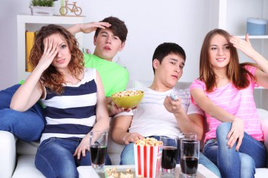 Grup genç arkadaşlar evde televizyon izlerken