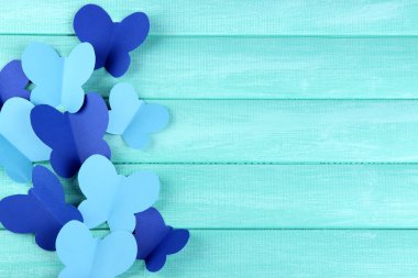 Kağıt ahşap zemin üzerinde kelebekler kesmek