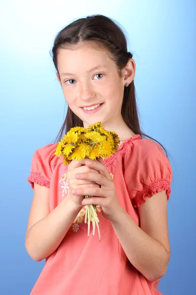 Retrato de una hermosa niña con dientes de león sobre fondo azul —  Fotos de Stock