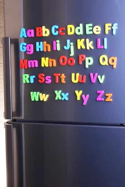 在冰箱上的彩色磁性字母 — 图库照片