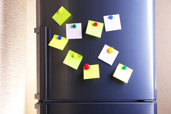 Empty paper sheets and colorful magnets on fridge door — Stock Photo, Image