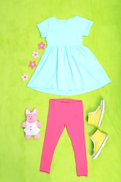 Beautiful clothes for little girl on green background — Stock Photo, Image