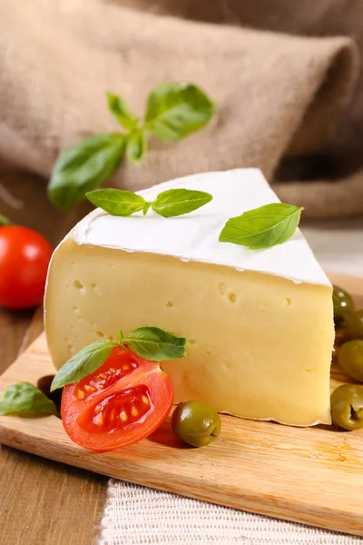 Gustoso formaggio Camembert con pomodori, olive e basilico, su tavola di legno — Foto Stock