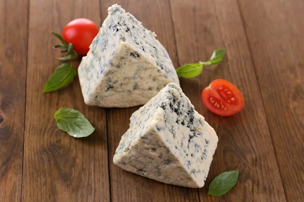 Tasty blue cheese with basil and tomato, on wooden table — Stock Photo, Image