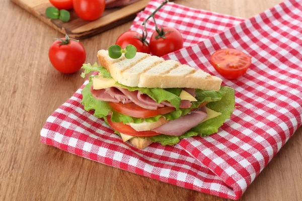 Matig smörgås med skinka på träbord — Stockfoto