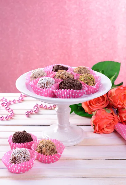 Set van chocolade snoepjes op tafel op roze achtergrond — Stockfoto