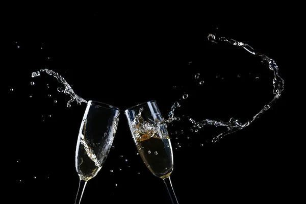 Glazen champagne met splash, op zwarte achtergrond — Stockfoto