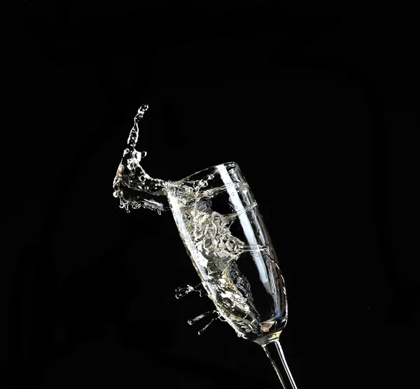 喝杯香槟时溅起水花，在黑色的背景上 — 图库照片