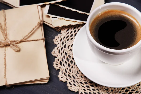 Xícara de café e velhas fotos em branco, no fundo de madeira — Fotografia de Stock