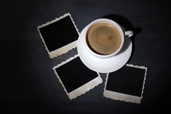 Šálek kávy a prázdné fotografie, na dřevěné pozadí — Stock fotografie