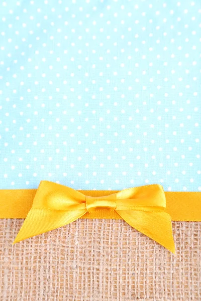Pytloviny s color ribbon a luk na pozadí barevných tkanin — Stock fotografie