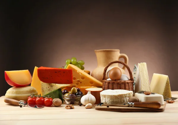 Tasty dairy products on wooden table, on dark background — Stock Photo, Image