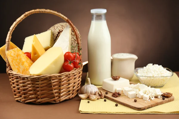 Sepet ve koyu kahverengi zemin üzerine ahşap masa üstünde lezzetli süt ürünleri — Stok fotoğraf