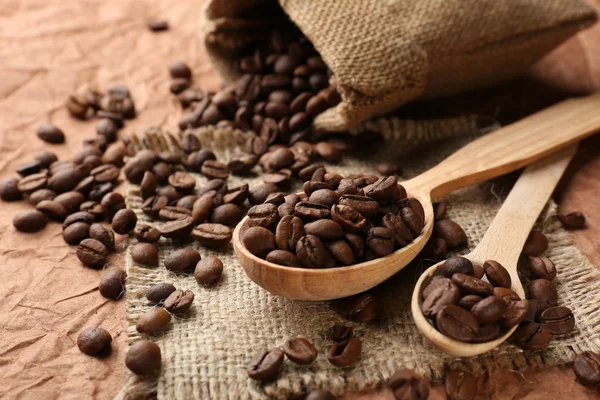 Coffee beans in sack on table close-up — Stock Photo, Image