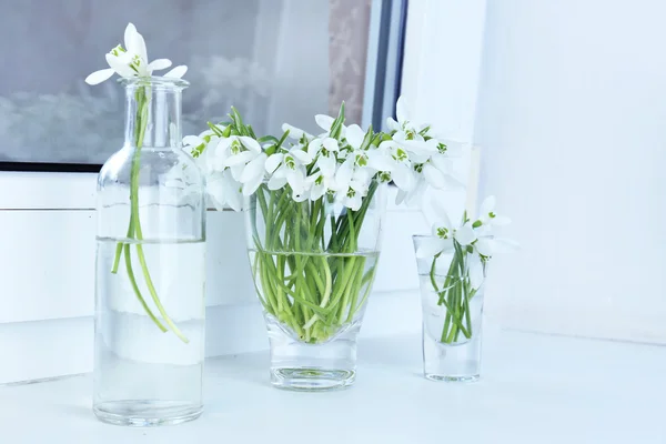 Vakre buketter med snødråper i vaser på vinduskarmen – stockfoto