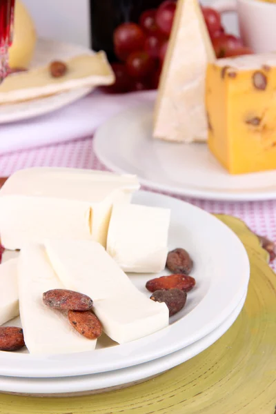 Assorted cheese plate on pink tablecloth background, close-up — Stock Photo, Image