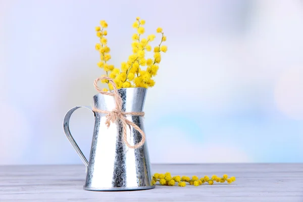 Galhos de flores de mimosa em vaso na mesa de madeira — Fotografia de Stock